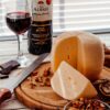 Mesa con vino tinto, queso y onzas oscuras preparadas para el maridaje de vinos y chocolates