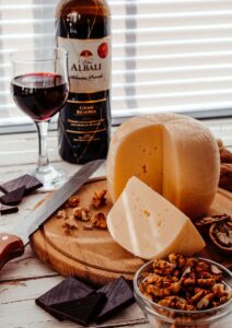 Mesa con vino tinto, queso y onzas oscuras preparadas para el maridaje de vinos y chocolates