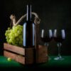 Bodegón elegante con botella de vino, uvas frescas y dos copas de tinto que ilustra la diferencia entre vinos monovarietales vs coupage.